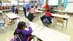 Binasa Musovic (left), an educational paraprofessional, and teacher Chris Frank (right), teach blended learning students on the first day back to school, December 7, 2020, at Yung Wing School P.S. 124 in New York Cit