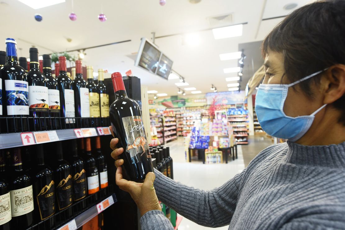 A customer looks at a bottle of wine imported from Australia at a supermarket on November 27 in Hangzhou, Zhejiang Province of China.