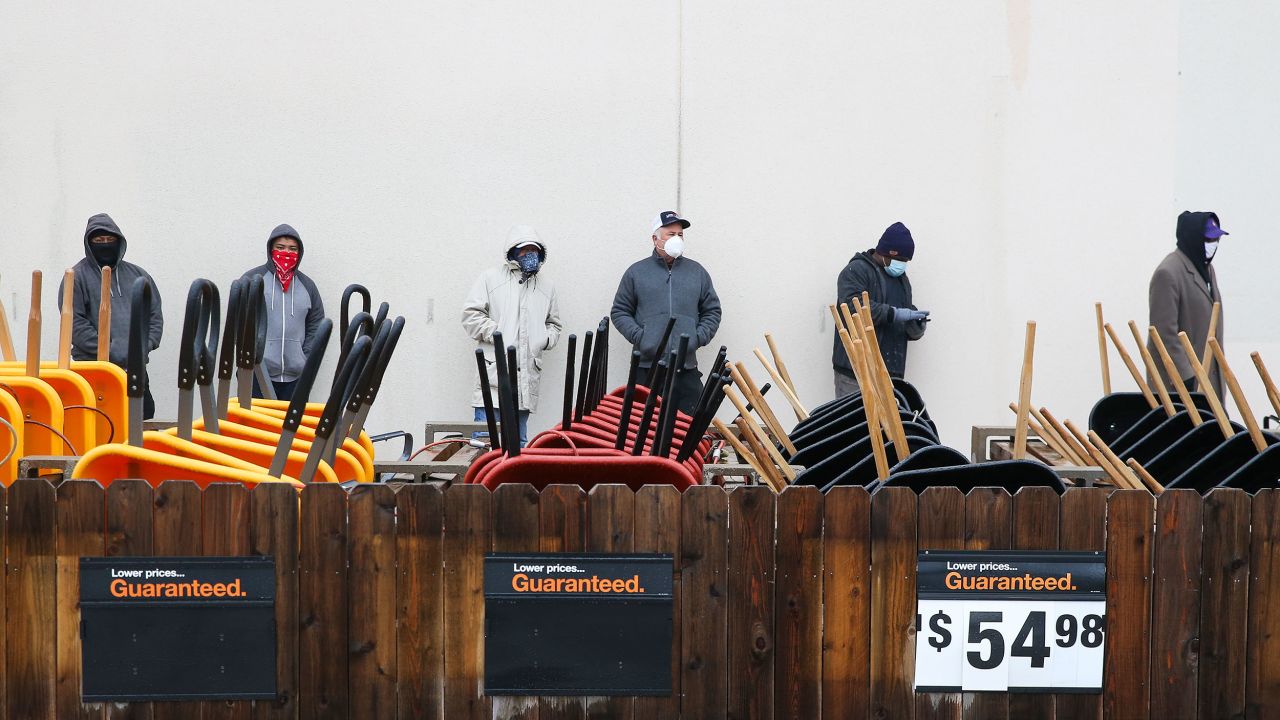 Customers wait outside a Home Depot in Pearland, Texas, to enter to buy needed supplies.
