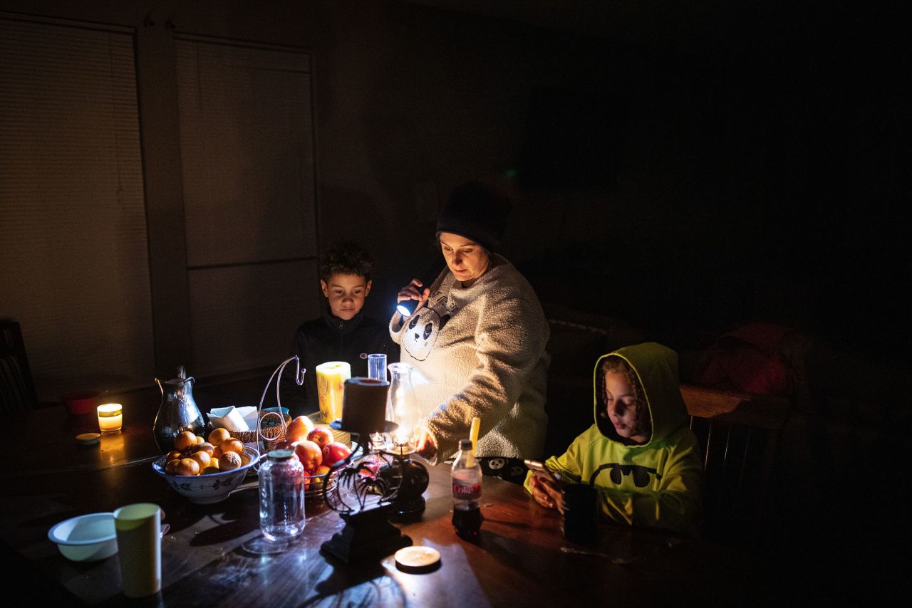 Manessa Grady adjusts an oil lamp while spending time with her sons Zechariah and Noah at their home in Austin on Tuesday, February 16.