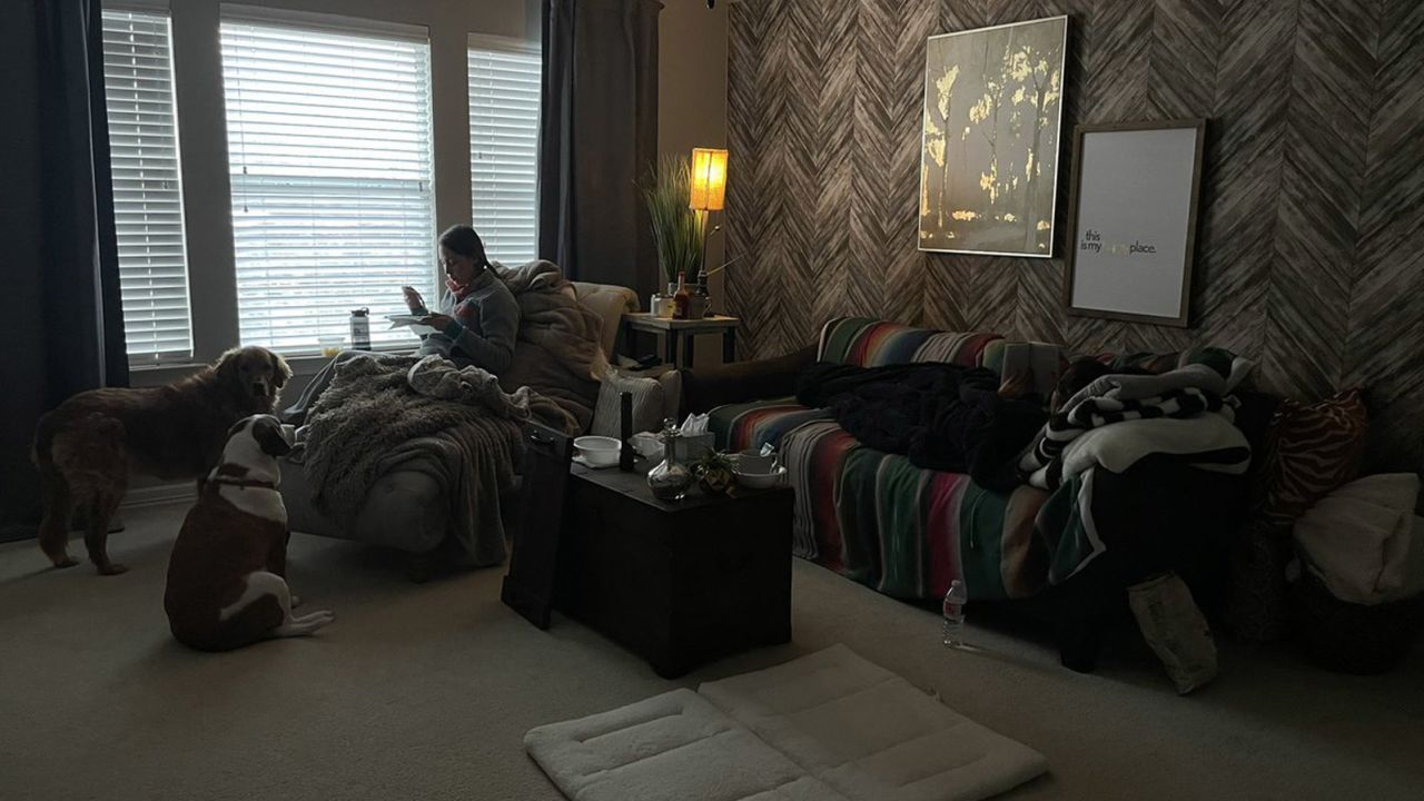 Gina Escajeda (left) sits in a room with Starla Everett (on the couch, right), who welcomed Gina and Adrian Escajeda into her home while their power was out.