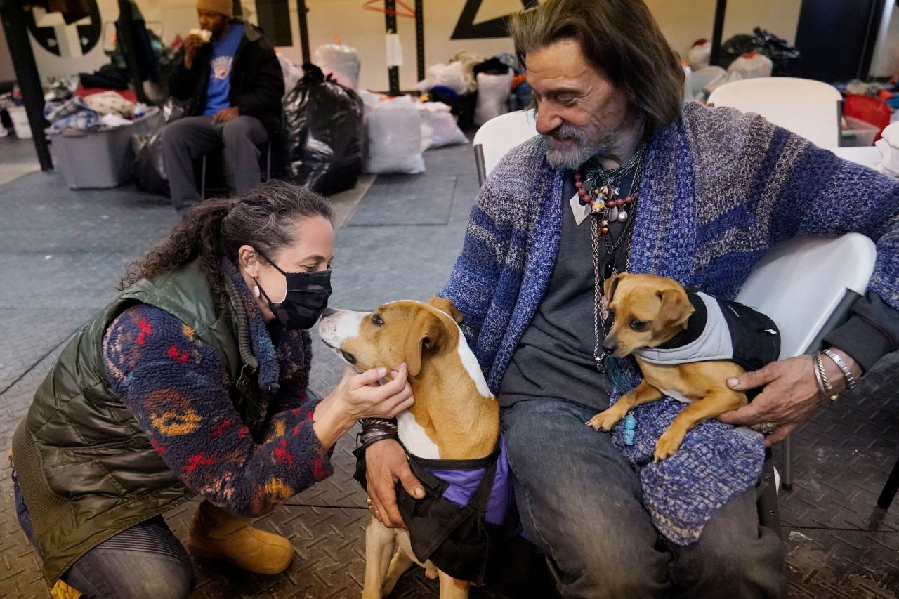 Kendra Clements visits dog owner Billy Madden -- with his dogs Leroy Brown and Underdog -- at Tribe Gym, an Oklahoma City gym that has been turned into a temporary homeless shelter.