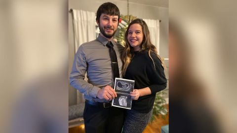 Caroline Nyczak and her husband, Steve, holding up their sonogram pictures in December 2020. 