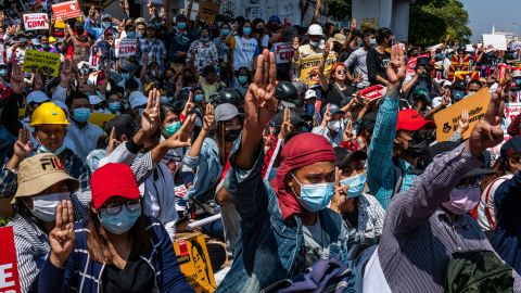 Protesters make three-fingered salutes and chant slogans during an anti-coup protest at Sule Square on February 17, 2021 in Yangon, Myanmar. 