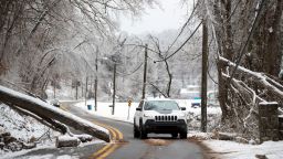 A vehicle navigates around a downed tree along Green Valley Road, as the area continues to deal with the fall out from winter weather on Wednesday, Feb. 17, 2021, in Huntington, W.Va. 