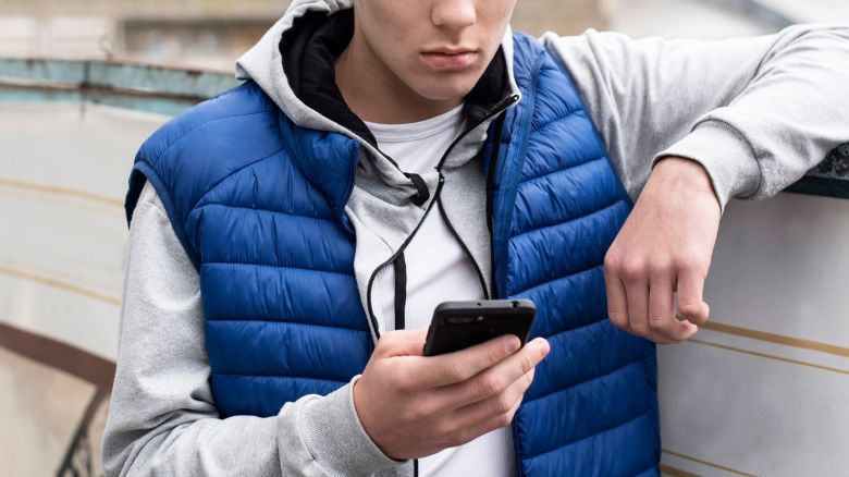 A teenage boy looking at a phone