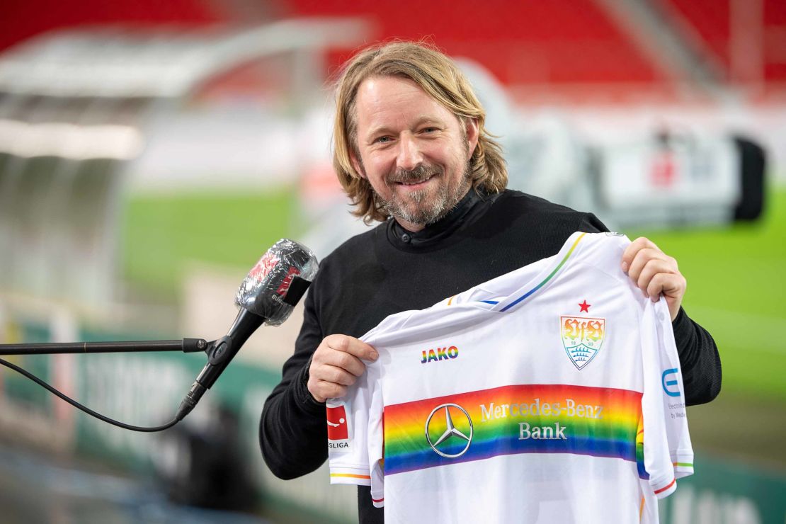 Sven Mislintat, sporting director for VfB Stuttgart, holds a jersey with the rainbow design in support of LGBTQ footballers.