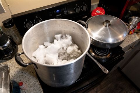 A family in Austin melts snow on their stove so that they could have water to flush toilets and wash dishes on Wednesday. Their electricity had been restored, but they still didn't have running water.