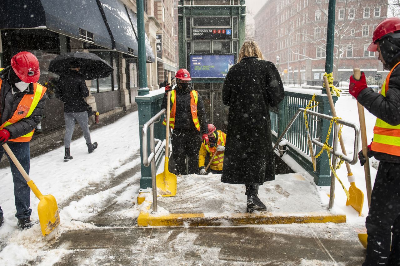 Metropolitan Transit Authority workers shovel the stairs of a subway station in New York City on Thursday.