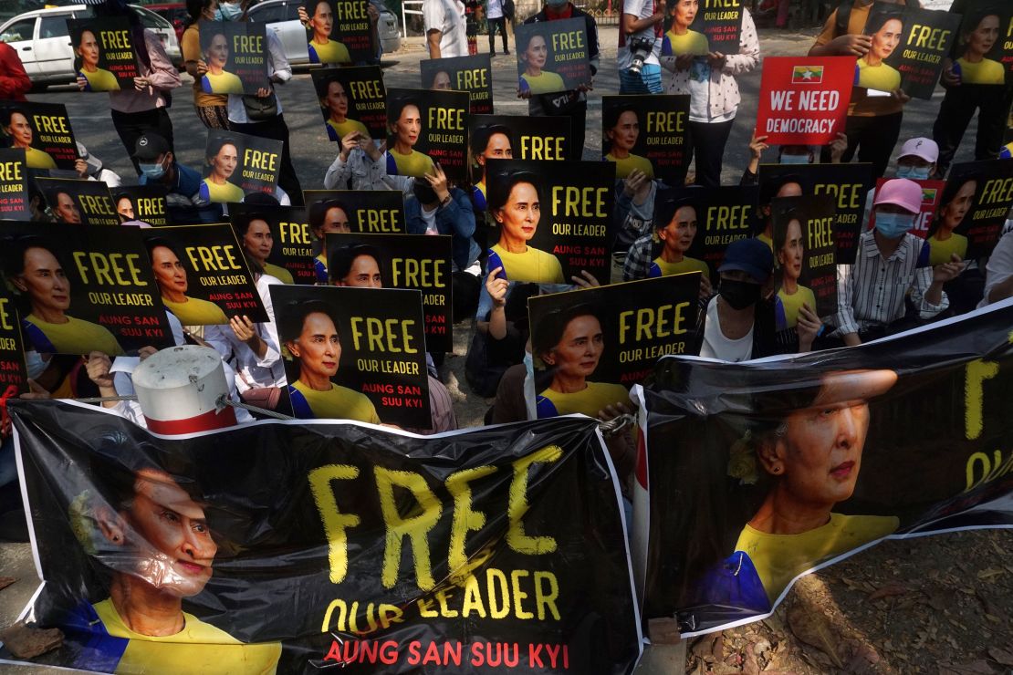 Protesters hold up signs demanding the release of detained Myanmar leader Aung San Suu Kyi outside the French Embassy in Yangon on February 19.