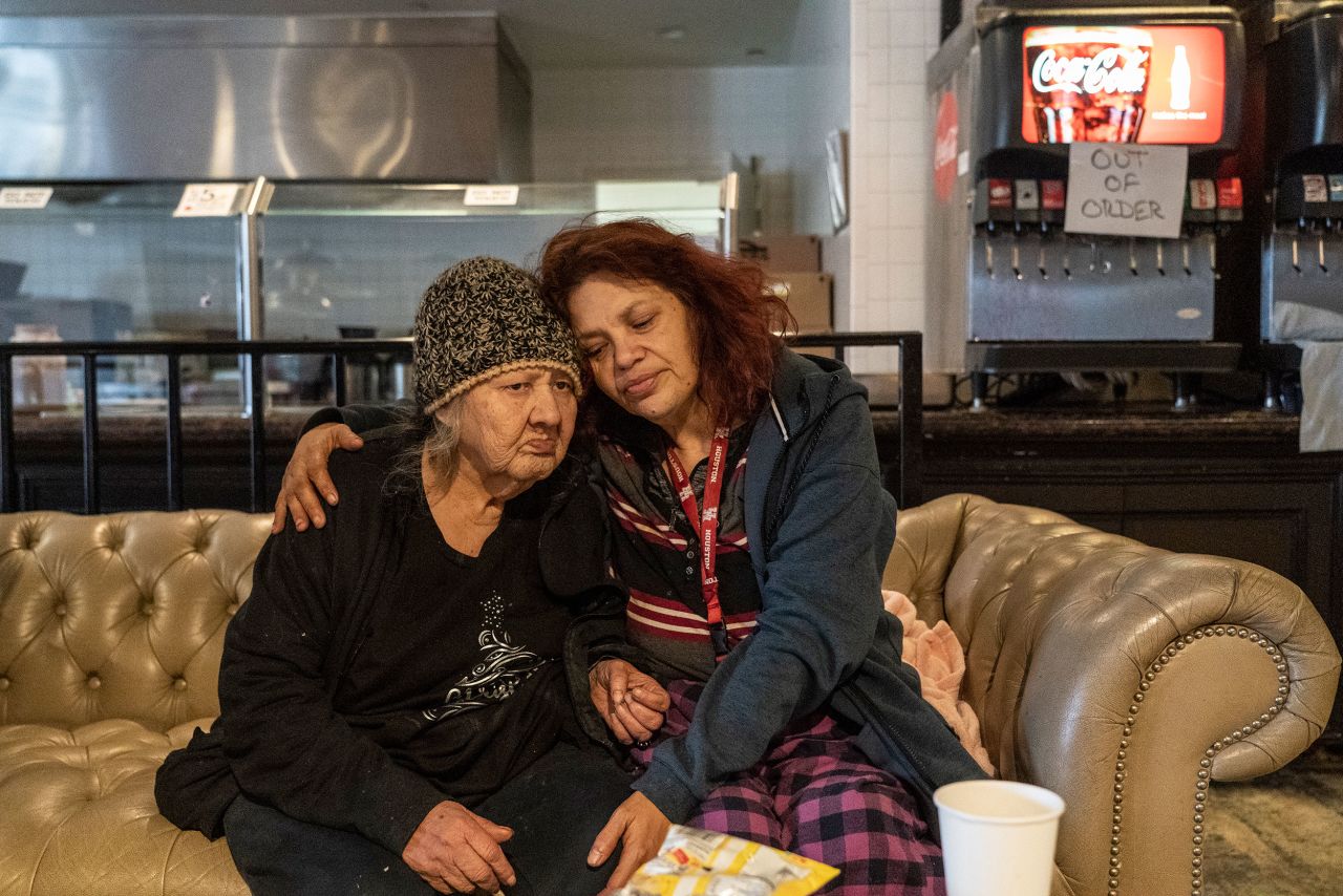 Deloris Sanchez and Mallissa Lee sit on a couch while taking shelter at a Gallery Furniture store that was serving as a warming station in Houston.