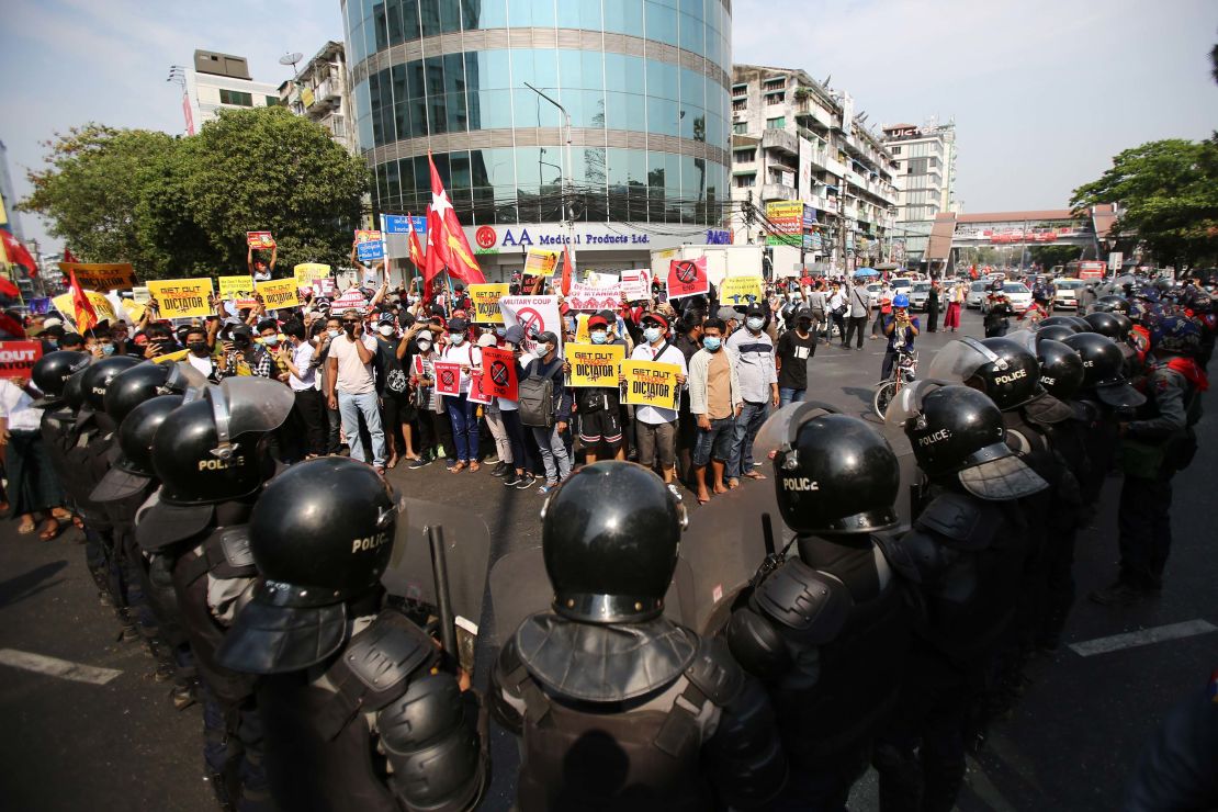 Anti-coup protesters face a row of riot police in Yangon on February 19.
