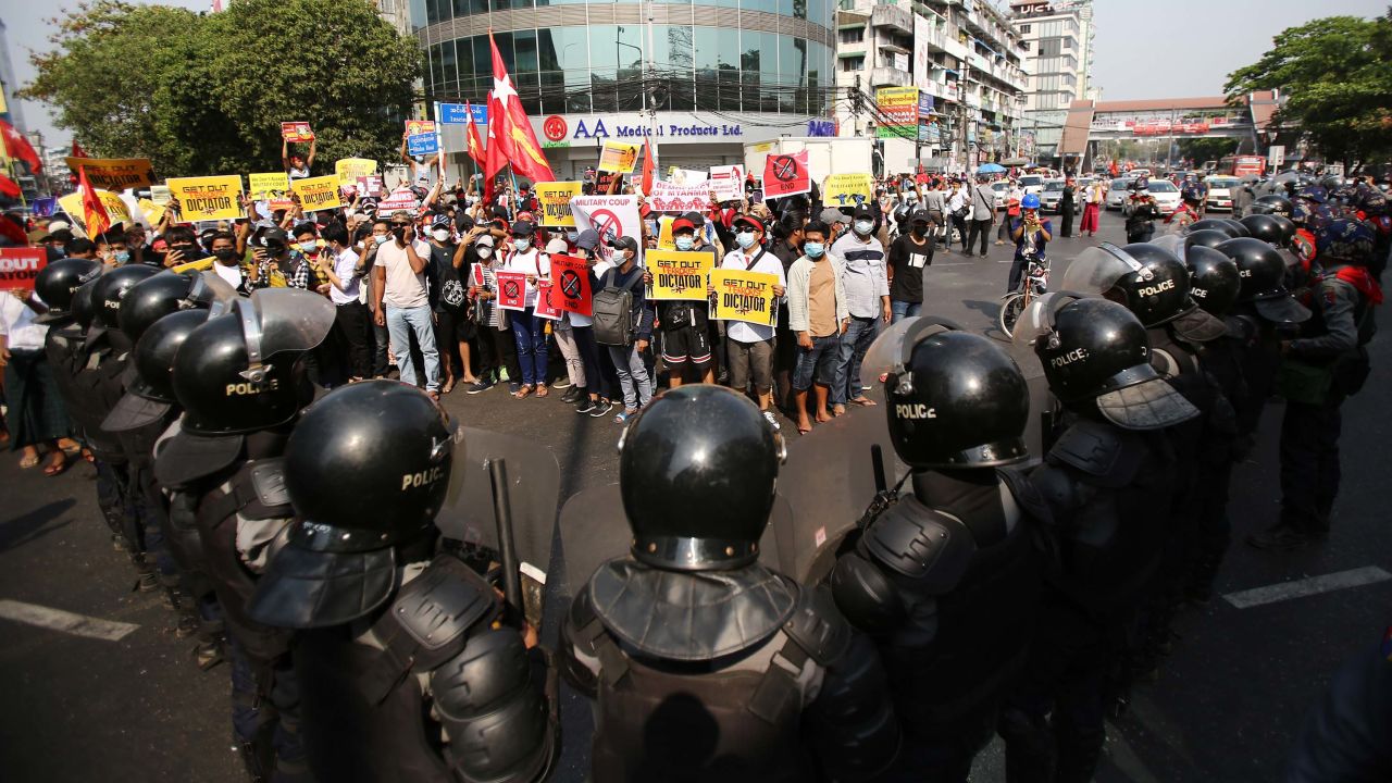 Anti-coup protesters face a row of riot police in Yangon on February 19.