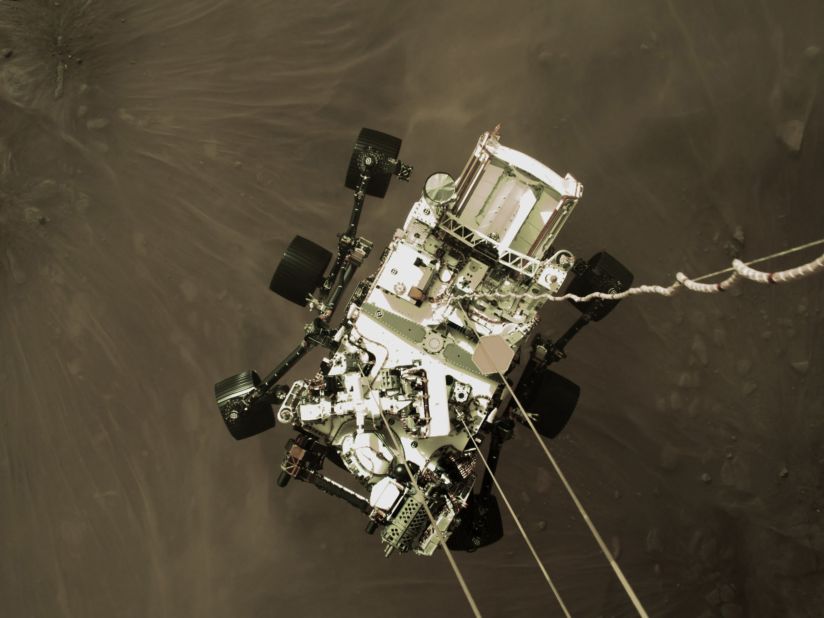 This image, from a camera on Perseverance's "jetpack" during the spacecraft's descent stage, captures the rover in midair just before its wheels touched down. This perspective has never been seen before on previous missions.