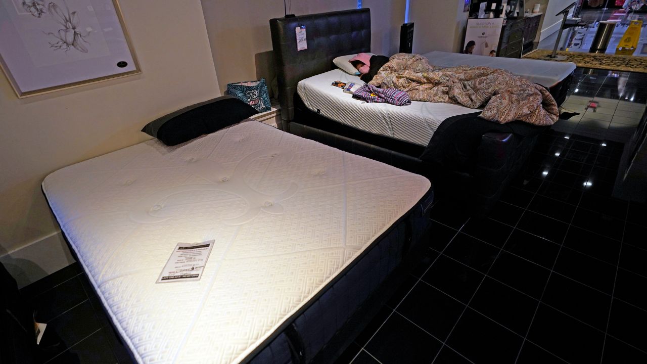 Dialina Gonzalez sleeps on a mattress inside a Gallery Furniture store which opened as a shelter Wednesday, Feb. 17, 2021, in Houston.