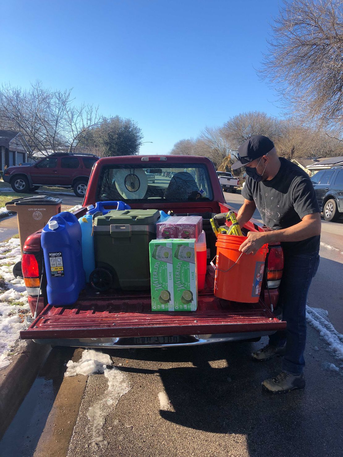 Texas Tribune Chief Creative Officer Jacob Villanueva loads water supplies into his truck in South Austin. He picked up a load of water at the home of Photo Editor Miguel Gutierrez Jr.