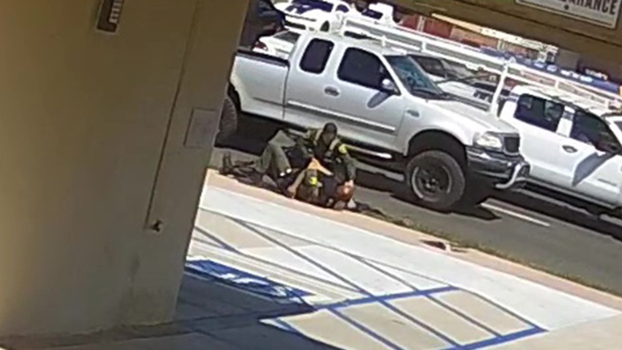 Video from a nearby surveillance camera shows two Orange County sheriff's deputies struggling with 42-year-old Kurt Reinhold, who they initially stopped for jaywalking.