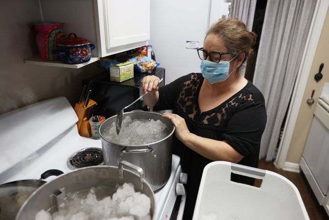 Marie Maybou melts snow on a kitchen stove in Austin, Texas, on Friday,  February 19. She was using the water to flush the toilets in her home after <a href="http://www.cnn.com/2021/02/16/weather/gallery/snowstorm-photos-february-2021/index.html" target="_blank">winter storms crippled the city's water supply.</a>