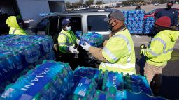 Water is loaded into a vehicle at a City of Houston water distribution site Friday, Feb. 19, 2021, in Houston. The drive-thru stadium location was setup to provide bottled water to individuals who need water while the city remains on a boil water notice or because they lack water at home due to frozen or broken pipes. (AP Photo/David J. Phillip)