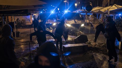 Demonstrators throw objects towards police during a protest condemning the arrest of repper Pablo Hasél in Barcelona on Friday