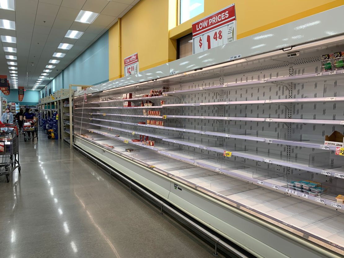 Shoppers are seen wandering next to near-empty shelves in a supermarket in Houston, Texas on February 20, 2021