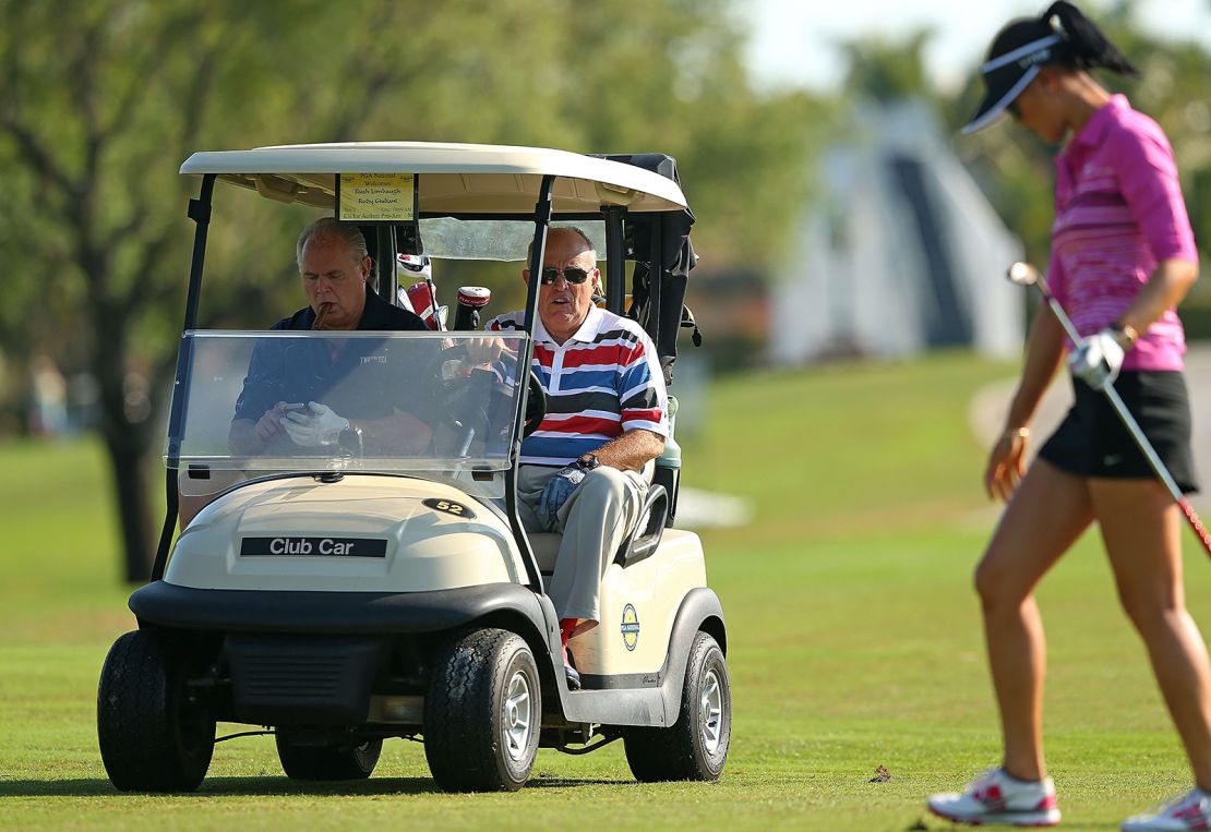 Former New York City Mayor Rudy Guliani and Rush Limbaugh look on as Michelle Wie plays during the Els for Autism Pro-am at The PGA National Golf Club  on March 10, 2014 in Palm Beach, Florida. 