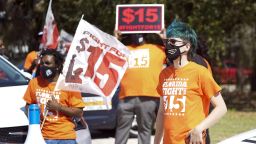 Cristian Cardona, right, an employee at a McDonald's, attends a rally for a $15 an hour minimum wage Tuesday, Feb. 16, 2021, in Orlando, Fla. (AP Photo/John Raoux)