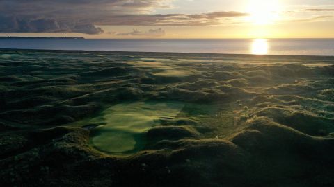 An aerial view of the par 4, eighth hole looking back to the tee from the green as the sun rises at The Royal St. George's Club.