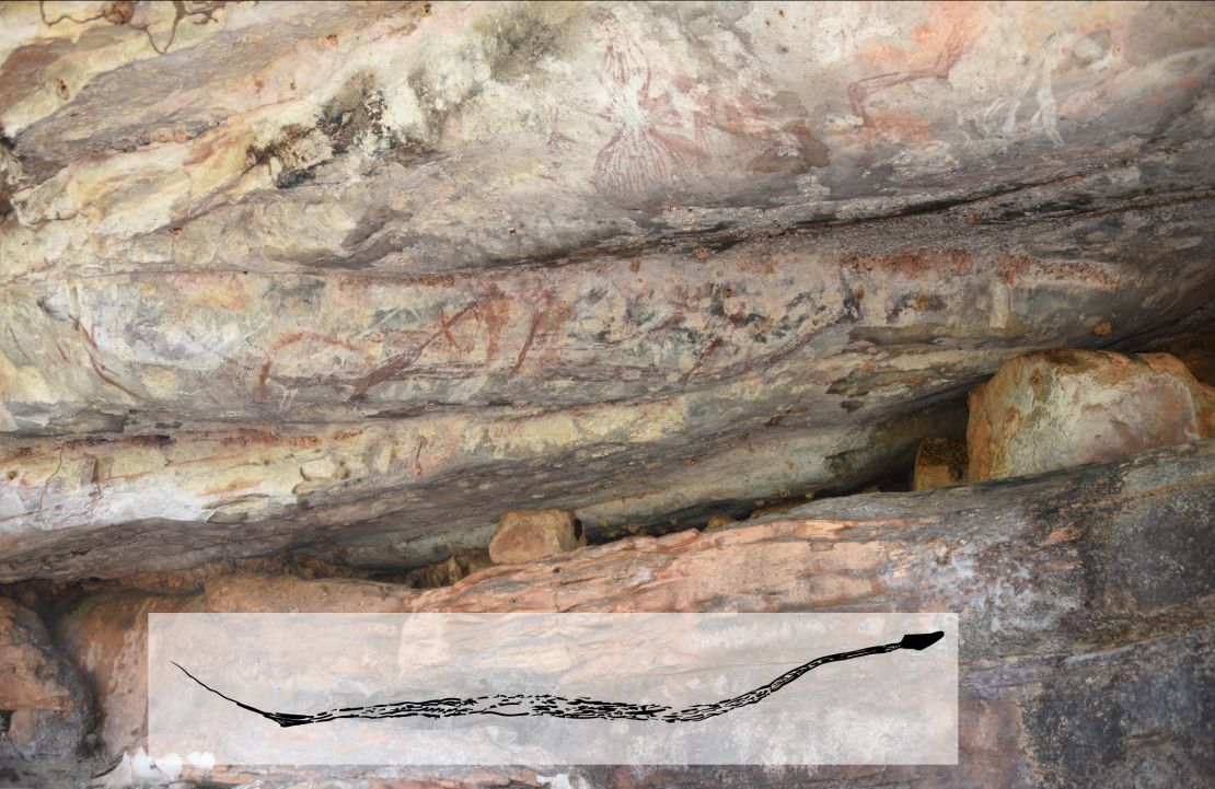 A painting of a snake at a rock shelter wall in Kimberley, with many other paintings painted over it. 