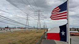The U.S. and Texas flags fly in front of high voltage transmission towers on February 21, 2021 in Houston, Texas. Millions of Texans lost power when winter storm Uri hit the state and knocked out coal, natural gas and nuclear plants that were unprepared for the freezing temperatures brought on by the storm. Wind turbines that provide an estimated 24 percent of energy to the state became inoperable when they froze. (Photo by Justin Sullivan/Getty Images)