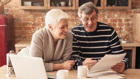 underscored senior couple looking at life insurance papers