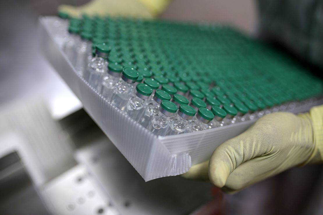 An employees handles vials of the AstraZeneca vaccine on the production of line at the Serum Institute of India.