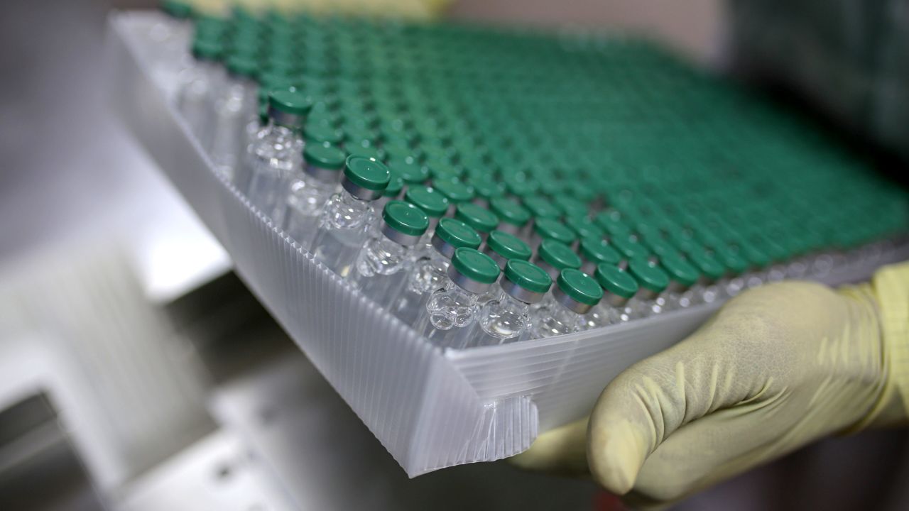 An employees handles vials of the AstraZeneca vaccine on the production of line at the Serum Institute of India.