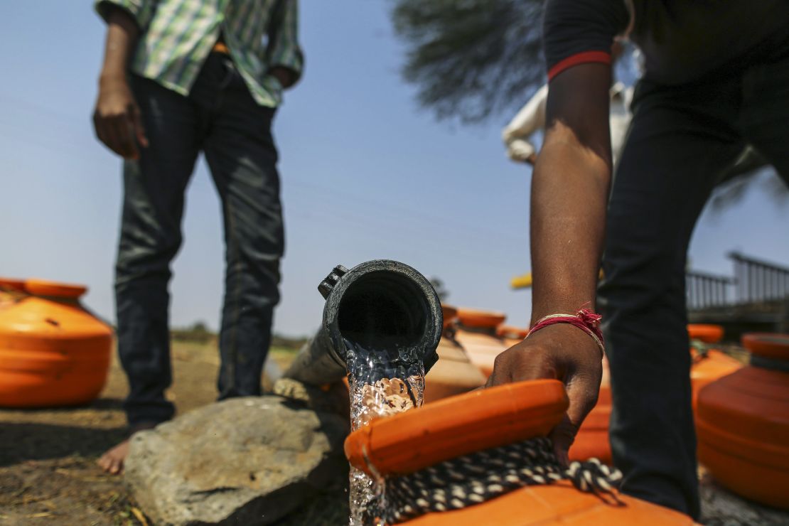 Water commuters fill containers at a groundwater source in Latur, Maharashtra, India, in 2016. 