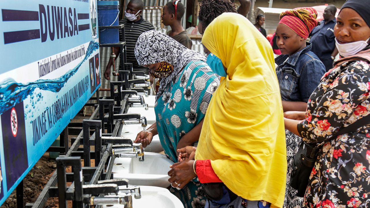 People use a hand-washing station installed for members of the public entering a market in Dodoma, Tanzania, on May 18, 2020.