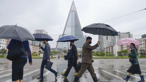 People walk in the rain in Pyongyang on May 15, 2020, wearing face masks amid the coronavirus pandemic.
