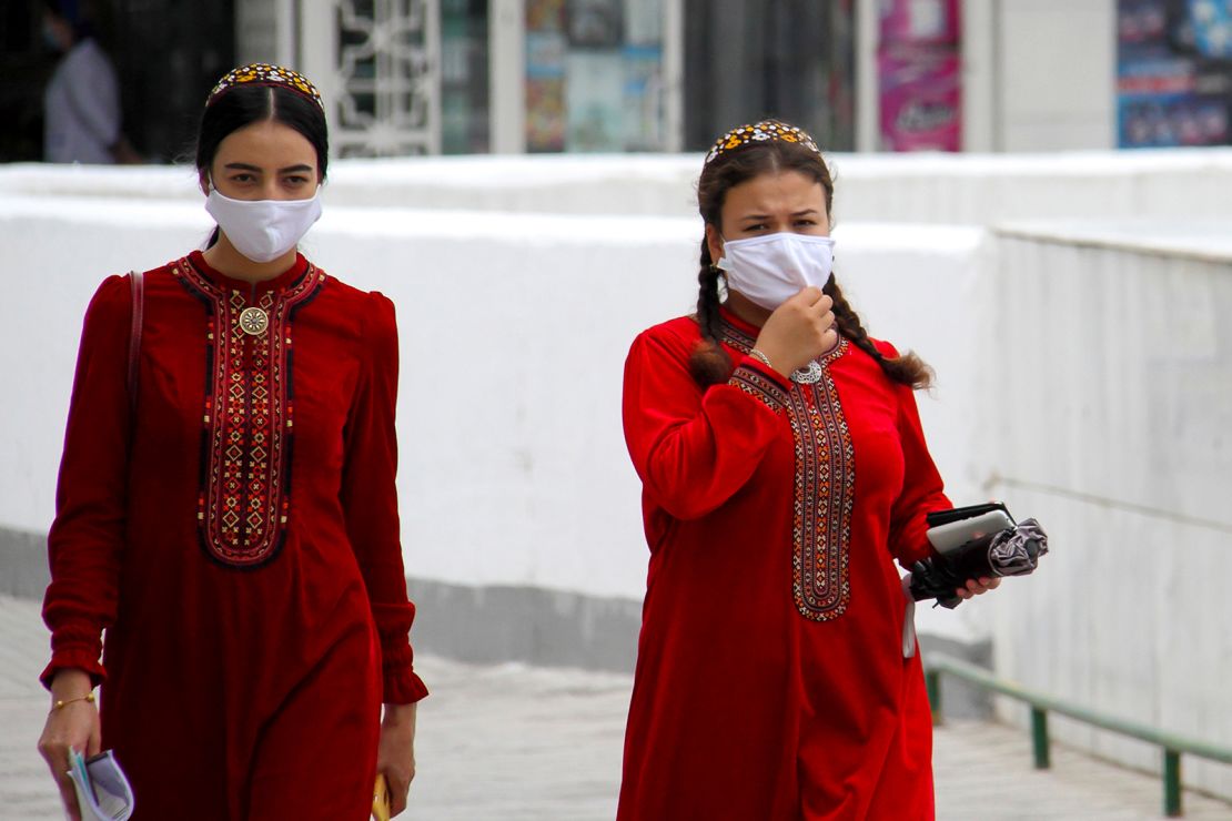 Turkmen women wearing face masks walk in Ashgabat on July 13, 2020.