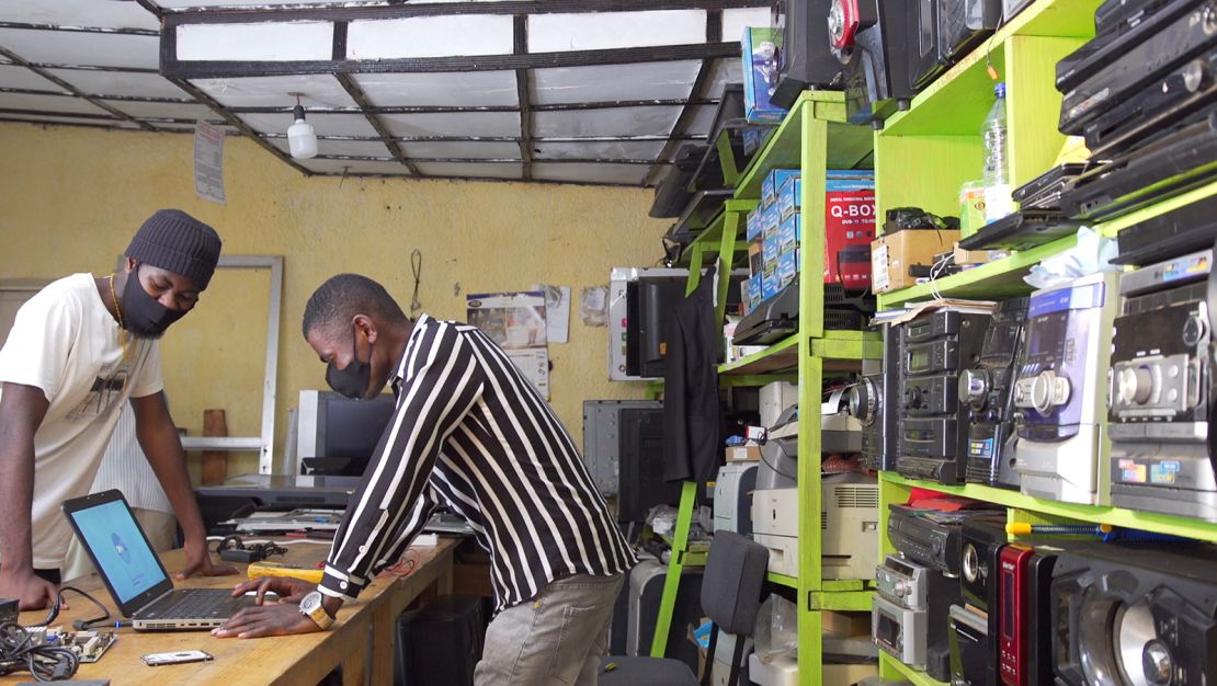 Eric Nshimiyimanain (right) owns two small electronic repair shops in Kigali, Rwanda.