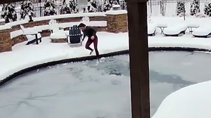 lady jumping in frozen pool to save dog