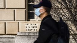 A man wearing a protective mask rides a scooter past the Internal Revenue Service (IRS) headquarters in Washington, D.C., U.S., on Saturday, Jan. 2, 2021. 