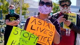 Demonstrators wearing face masks and holding signs take part in a rally to raise awareness of anti-Asian violence, near Chinatown in Los Angeles, California, on February 20, 2021. - The rally was organized in response to last month's fatal assault of Vicha Ratanapakdee, an 84-year-old immigrant from Thailand, in San Francisco. (Photo by RINGO CHIU / AFP) (Photo by RINGO CHIU/AFP via Getty Images)