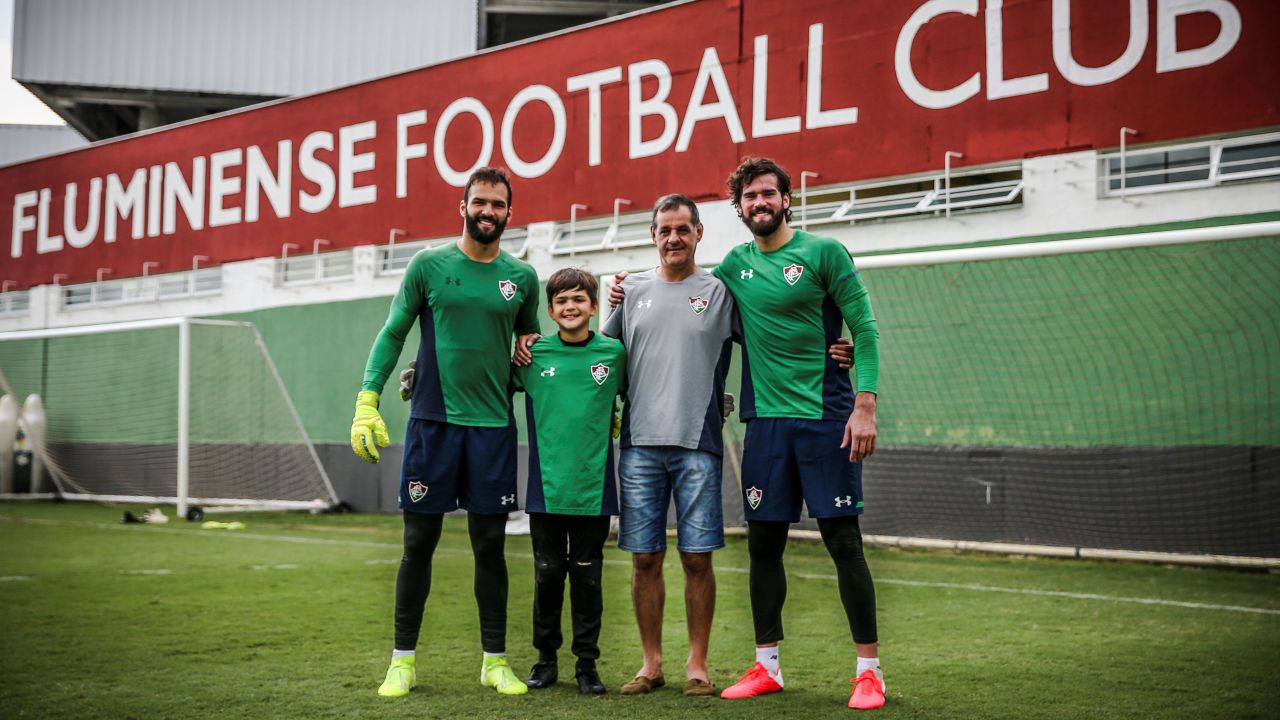 Liverpool goalkeeper Alisson (R) and brother Muriel (L) with father Jose Becker (2-R).
