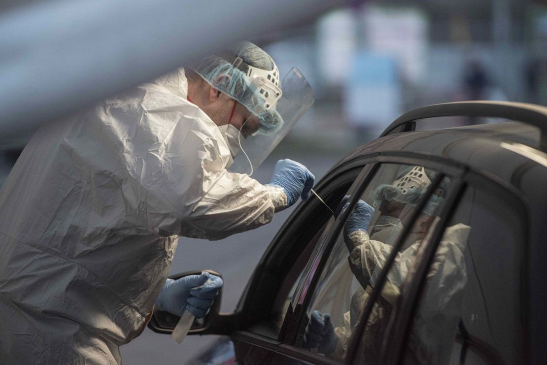A medical worker takes a sample from a person at the drive-in coronavirus testing station in Prague.