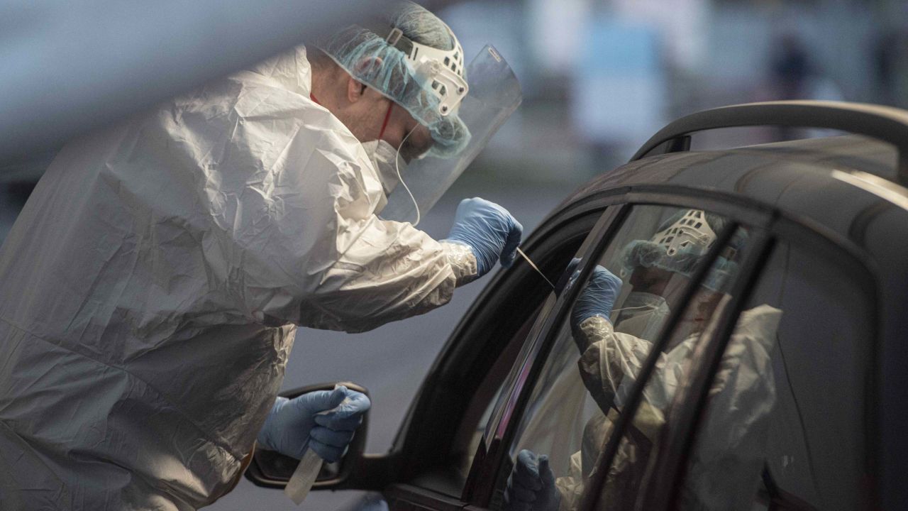 A medical worker takes a sample from a person at the drive-in coronavirus testing station in Prague.