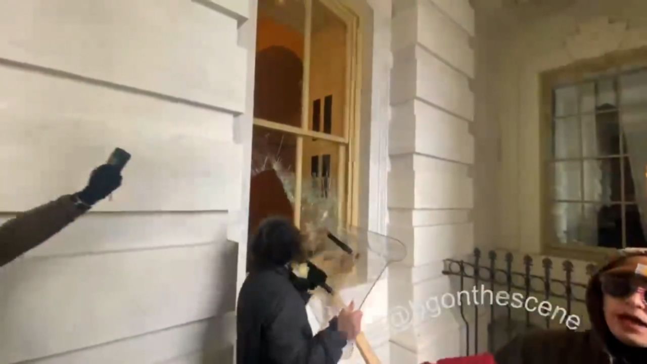 Dominic Pezzola smashes a window with a police riot shield