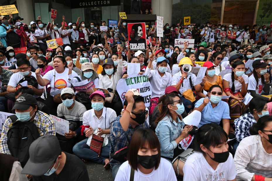 Factory workers hold placards and shout slogans as they hold an anti-coup protest in Yangon on February 25.