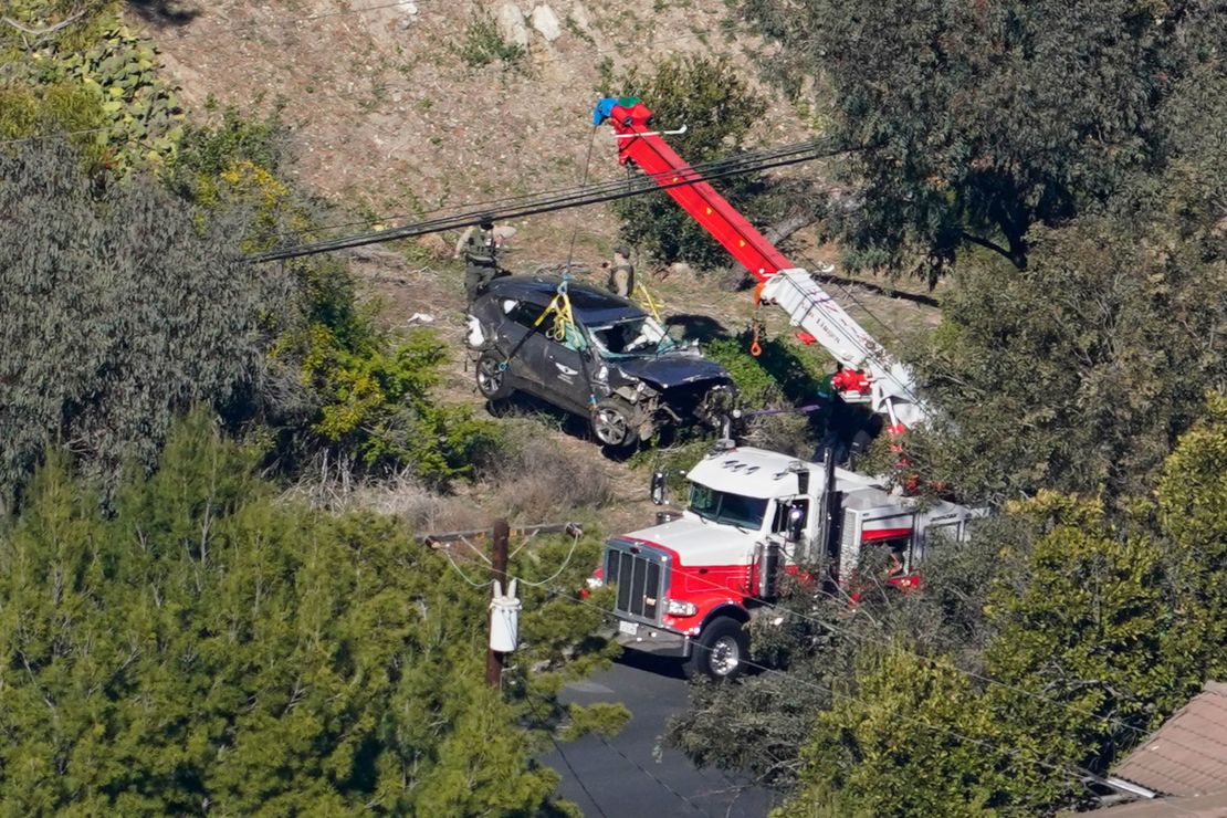 Workers move a vehicle after a rollover accident involving Tiger Woods on February 23, 2021