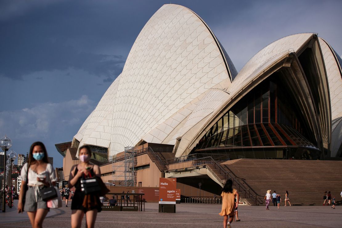 Pedestrians walk past the Sydney Opera House in Sydney, Australia on January 14, 2021.