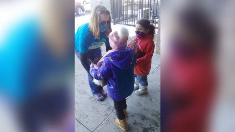 The Girl Scouts of Troop 64224 passing out boxes of cookies to a customer.
