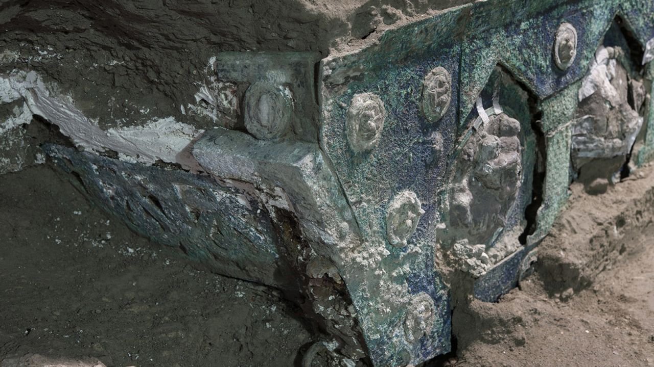 The chariot's engraved bronze and tin medallions, still covered in volcanic material